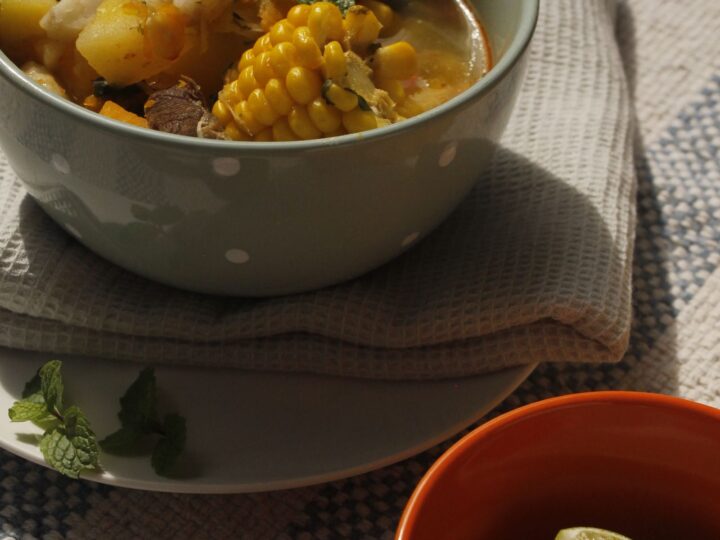 Sancocho con mazorca, tubérculos y carne en un plato hondo