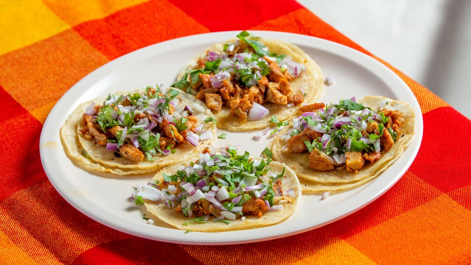Tortillas de maíz con pollo deshebrado, cebolla y cilantro